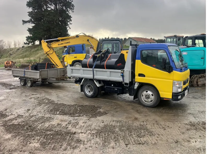 A small tipper and mini-excavator on a residential job